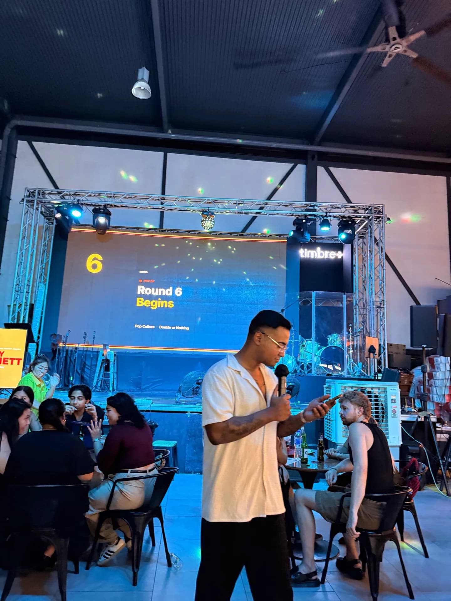 Armand hosting a live trivia night with a microphone